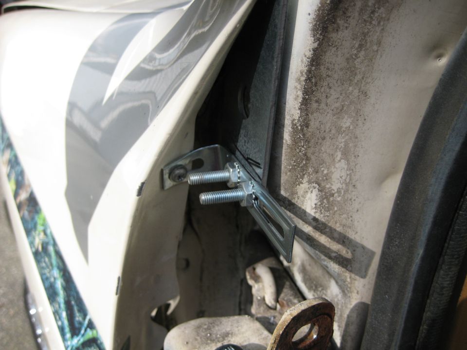 Door jamb with metal bracket and bolts attached