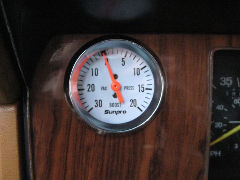 1980 Ford Bronco - A Sunpro boost gauge is visible within a wood-grain dashboard panel.