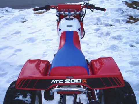 2000 Ford E350 - The rear of a red and blue ATC 200X three-wheeler is visible in the snow, with 'ATC 200X' clearly marked.