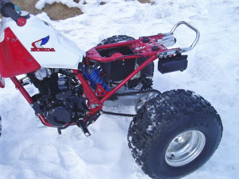 2000 Ford E350 - Honda ATV with red frame and white gas tank sits in the snow.