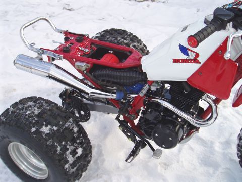 2000 Ford E350 - A red and white Honda three-wheeler sits in the snow, showing its engine and exhaust.