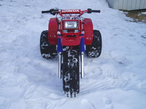 2000 Ford E350 - Red Honda ATV parked in the snow, front view. The handlebars clearly show the HONDA logo.