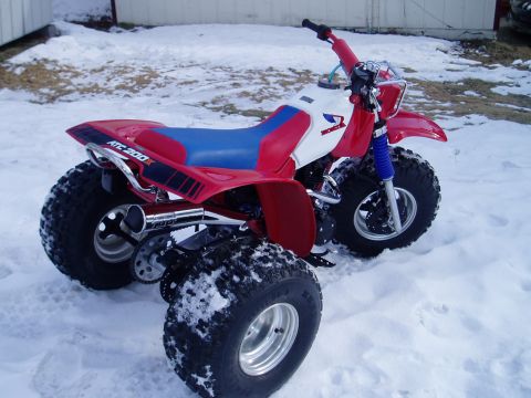 2000 Ford E350 - A red and white three-wheeled ATV sits in the snow, displaying 'ATC 200X' branding.