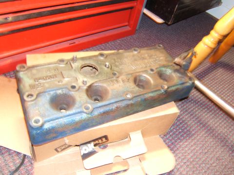 1946 Jeep CJ5 - This is an engine valve cover with visible text, resting on a cardboard box.