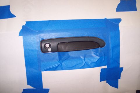 2001 Ford Crown Victoria - Car door handle taped to a surface for preparation or display.