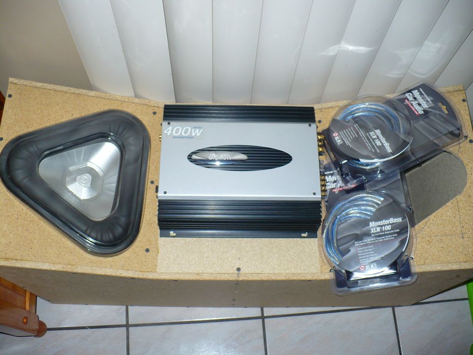 Car audio amplifier with 400w label, a triangular subwoofer, and two packages of MonsterBass XLR 100 cables