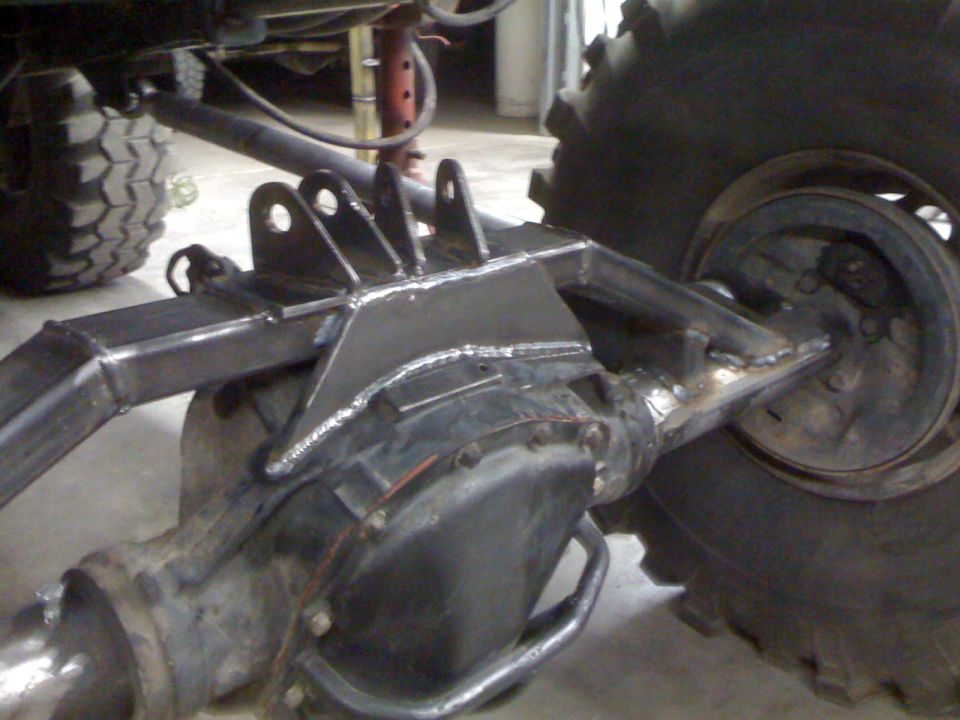 Freshly welded axle truss and link brackets over a solid axle differential housing