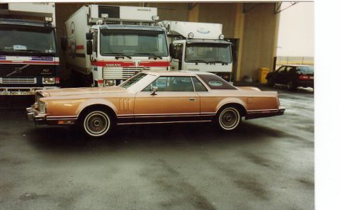1998 Ford Crown Victoria - Side view of a 1977 Lincoln Continental Mark V coupe with trucks in the background.