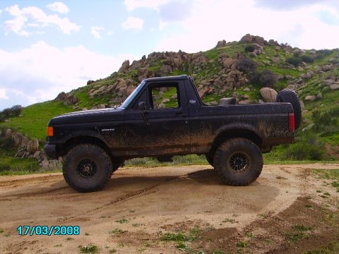 1990 Ford Bronco - This 1990 Ford Bronco is shown in a side profile, covered in mud, with off-road tires.