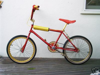 1979 Ford F-250 - A red and gold BMX bicycle is shown parked on a wooden deck against a white wall.