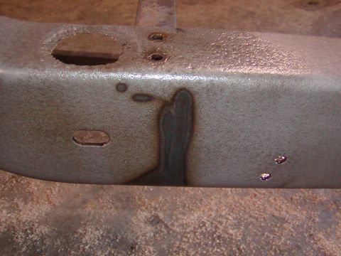 1991 Ford Bronco - This image shows a close-up of a rusted metal frame part with visible holes and discoloration.