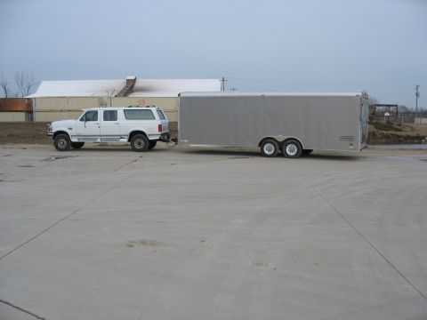 1995 Ford C-350 (Centurion Conversions) - Side view of a 1995 Ford C-350 SUV towing a large silver cargo trailer.