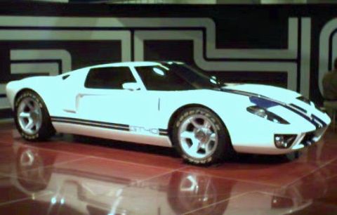 1981 Ford Bronco - A white sports car with blue racing stripes and 'GT40' badging is displayed on a reflective surface.