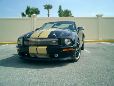 2007 Ford Mustang - Front view of a black 2007 Ford Mustang convertible with gold racing stripes.