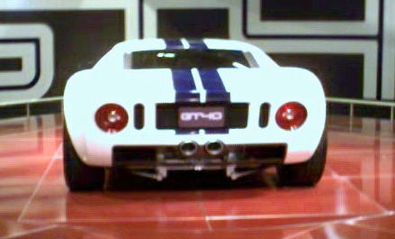 1981 Ford Bronco - Rear view of a white Ford GT40 with blue racing stripes and dual exhaust pipes.