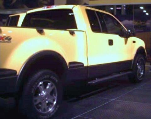 1981 Ford Bronco - A yellow pickup truck is shown from the rear quarter angle, with black trim and running boards.