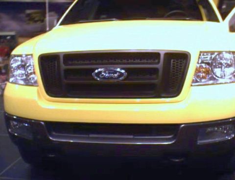 1981 Ford Bronco - Front view of a yellow Ford truck, focusing on the grille and headlights.