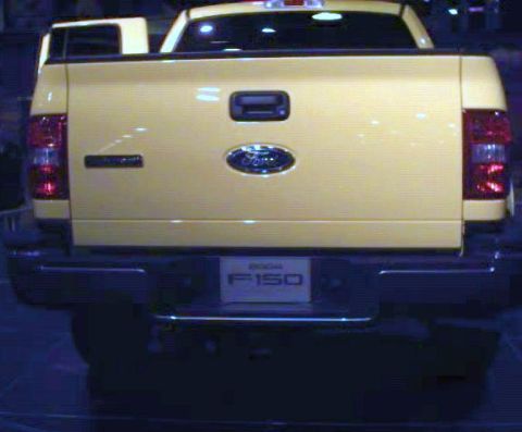1981 Ford Bronco - This yellow Ford F-150 pickup truck is seen from the rear, displaying its tailgate and bumper.
