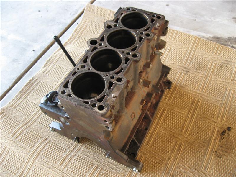 Engine block with four cylinders, resting on a patterned cloth