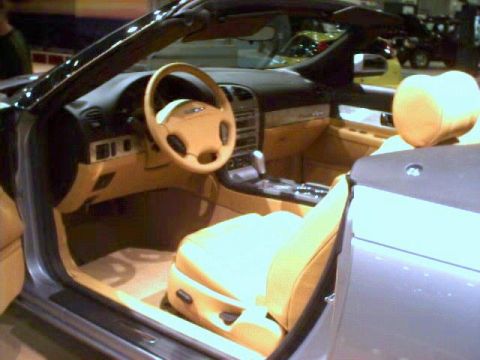 1981 Ford Bronco - The interior of a car features tan seats and a tan steering wheel, with the driver's side door open.