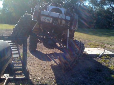 1966 Ford Bronco - Custom off-road vehicle with extensive suspension modifications and large tires is shown from the rear.