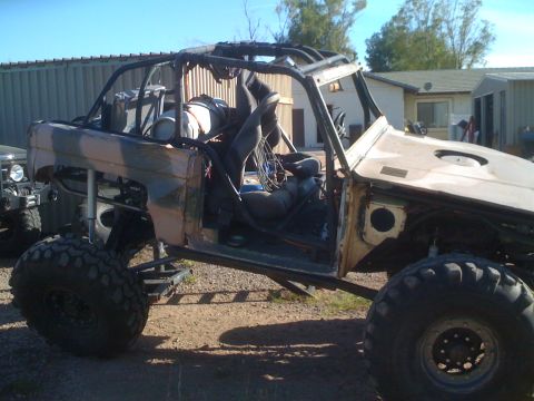 1966 Ford Bronco - Heavily modified 1966 Ford Bronco with custom roll cage and off-road tires. Another vehicle is visible to the left.