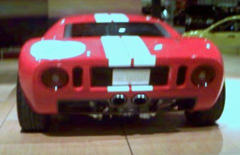 1981 Ford Bronco - This red sports car features a distinctive rear design with white racing stripes.