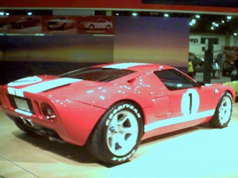 1981 Ford Bronco - A red sports car with white racing stripes and the number 1 is displayed indoors.