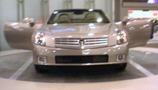 Silver convertible with doors open, front view