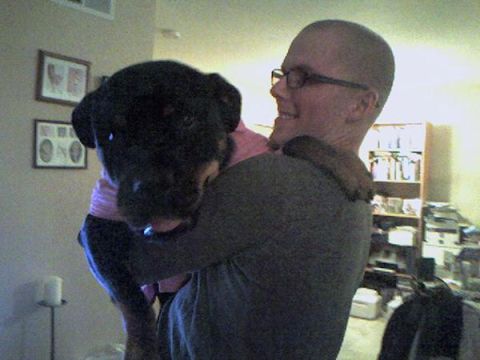 1996 Ford Bronco - A person holds a large black dog wearing a pink shirt indoors.