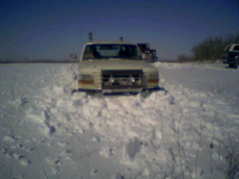1992 Ford F-350 - A 1992 Ford F-350 is stuck in a snow-covered field with other vehicles nearby.