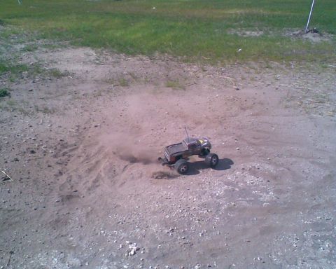 1984 Ford Bronco II - A remote control monster truck navigates a dusty outdoor track, demonstrating its off-road capabilities.