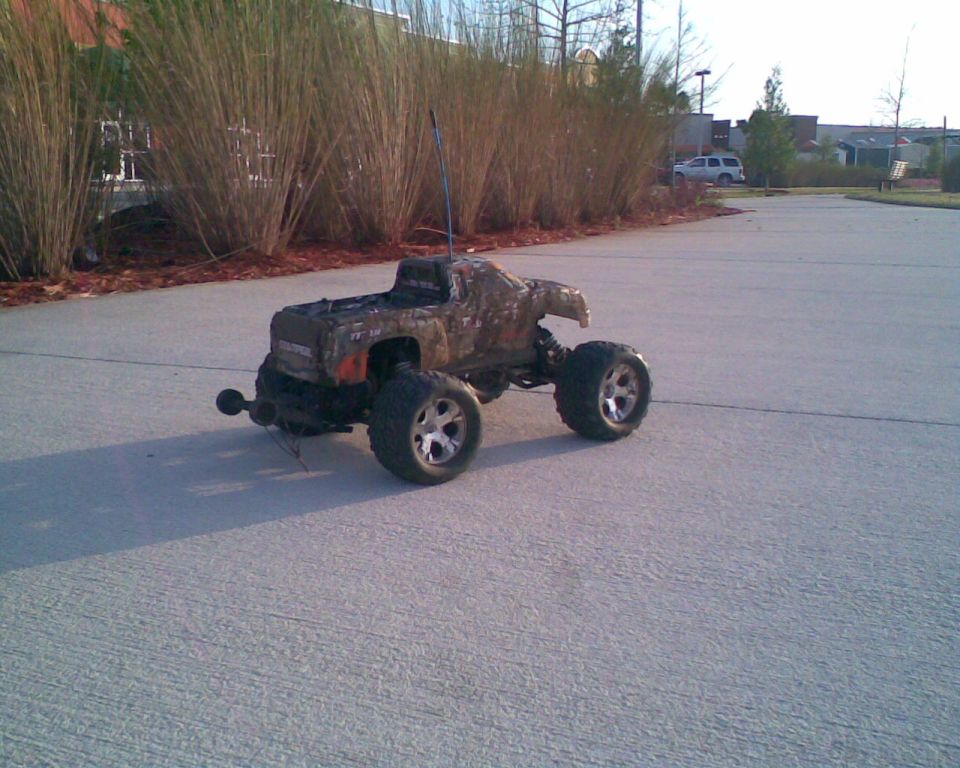Brown remote control monster truck with large tires on a paved surface