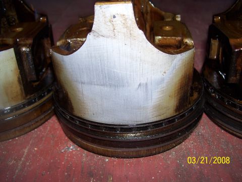 1978 Ford Bronco - Close-up of damaged pistons, showing wear and scoring on one cylinder wall.