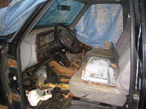 1987 Ford Bronco - The interior of this vehicle is in disarray, with debris covering the floor and seats.