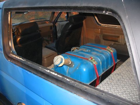1987 Ford Bronco - Interior view of a blue SUV with an auxiliary fuel tank installed behind the front seats.