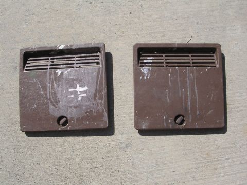 1983 Ferrari Enzo - Two brown vent covers with visible wear and tear are displayed on a concrete surface.
