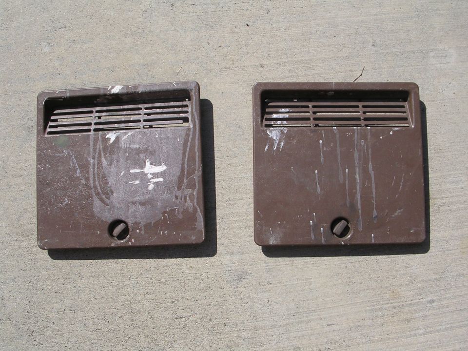 Pair of brown louvered interior vent kick panels with white paint splatter on concrete