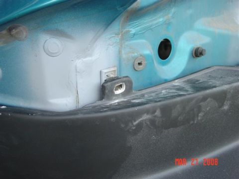 1993 Ford Probe - Close-up of a car's body panel and bumper, revealing mounting hardware and surface dust.