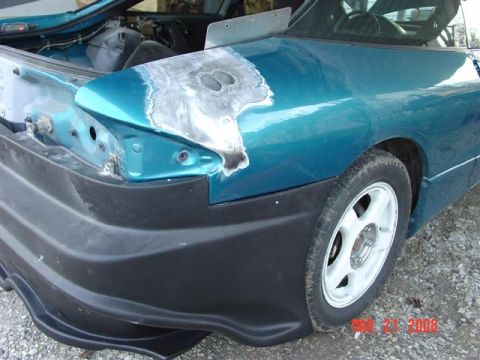 1993 Ford Probe - Bodywork in progress on a 1993 Ford Probe, showing filler on the rear quarter panel and a black bumper.