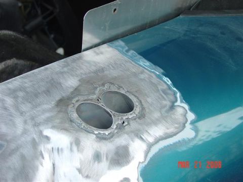 1993 Ford Probe - A close-up view of a car's body panel undergoing repair work, with metal being sanded and prepped.