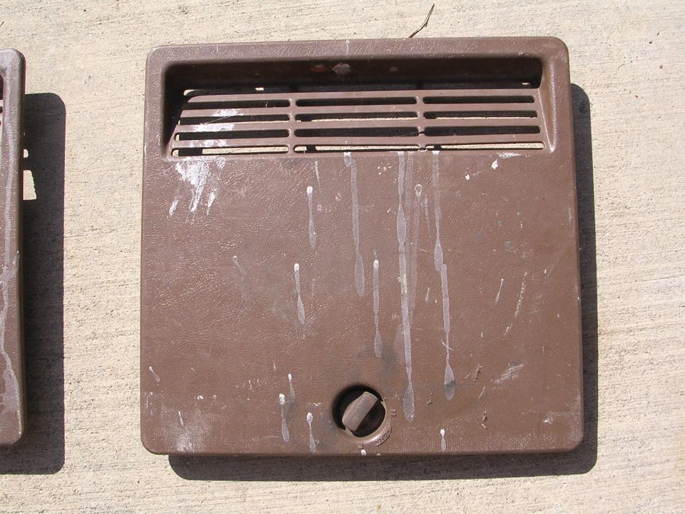 Brown plastic vent cover with horizontal slats and a central knob
