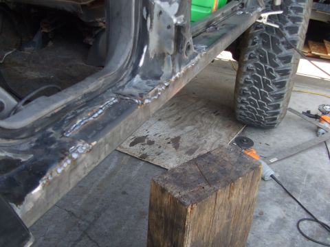 1994 Jeep Cherokee - Close-up of a vehicle's rocker panel undergoing repair with visible welding marks.