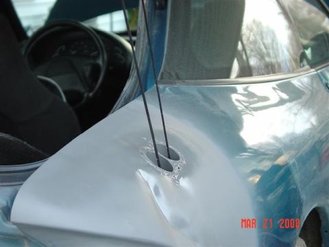 1993 Ford Probe - The rear quarter panel of a vehicle shows damage and two holes, with a date stamp of MAR 21 2008.