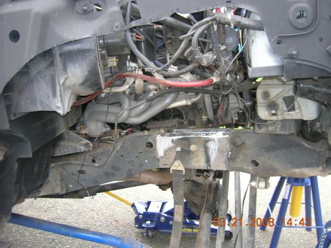1996 Ford Bronco - The vehicle's engine bay and frame are exposed, showing the exhaust headers and suspension components.