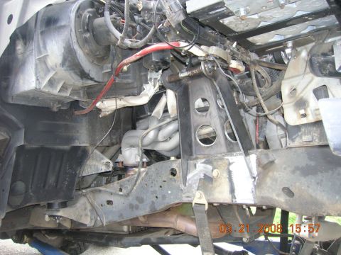 1996 Ford Bronco - Close-up view of the engine bay, highlighting custom suspension modifications and exhaust headers.