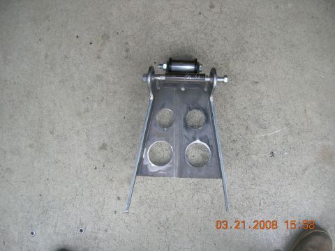 1996 Ford Bronco - Fabricated metal bracket with roller assembly, photographed on concrete floor.