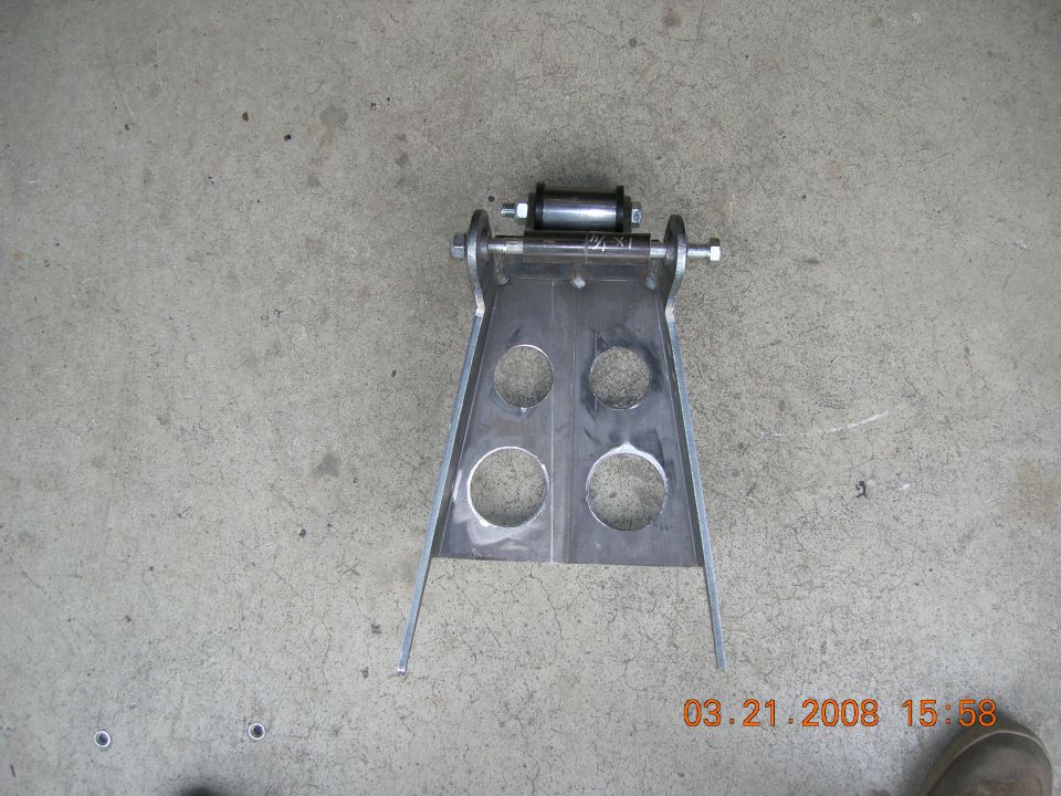 Custom fabricated metal bracket with four large circular cutouts and a roller assembly
