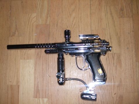 1988 Ford Bronco - Chrome paintball gun with black grip and air hose on wooden floor.