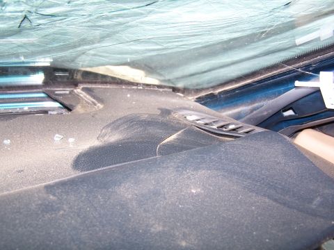1996 Ford Probe - The interior of a car's dashboard is covered in dust, with a view through the windshield.